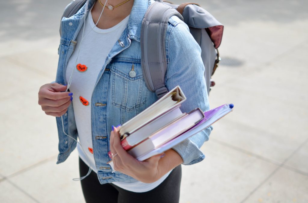 girl student with headphones, textbooks and a backpack – Nerdify Reviews 3 Benefits of Joining a Freshman Orientation Program in College